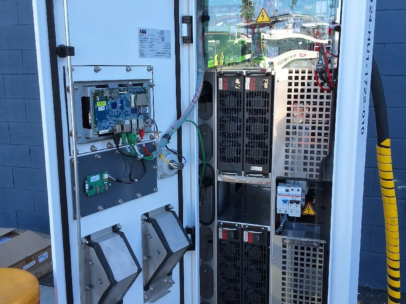 Open industrial EV charging cabinet undergoing repair