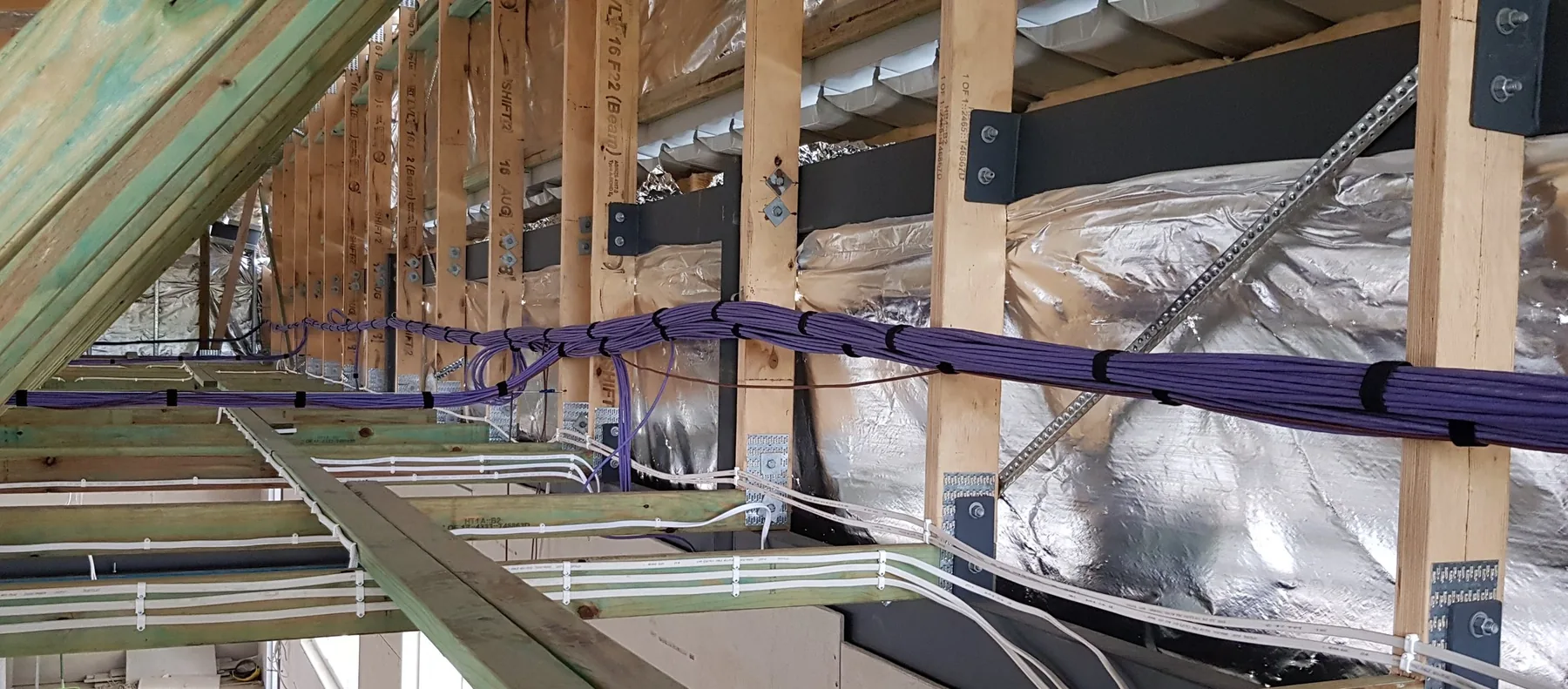 Communications cabling neatly installed within a building frame